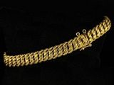 a close up of a gold bracelet on a black surface