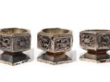 three silver rings on a stand on a white surface