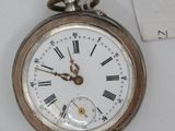 a silver pocket watch with roman numerals on it