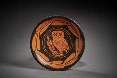 an orange and black bowl with an owl on it