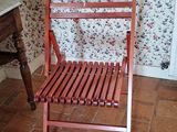 a wooden chair sitting in front of a wallpapered wall