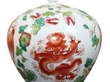 a white and red vase with a dragon on it