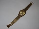 an image of a gold wrist watch on a white surface