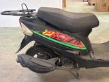 a black scooter with a green and red sticker on it