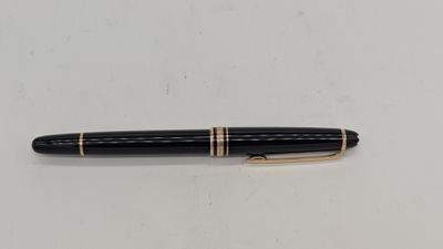un gros plan d'un stylo posé sur une surface blanche