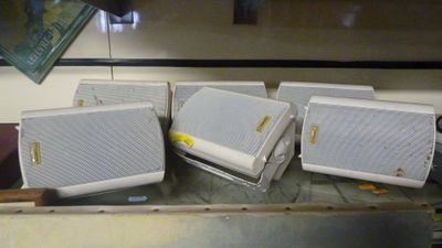 quatre enceintes blanches posées sur une table en métal