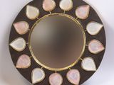 un miroir rond orné de pierres roses et blanches