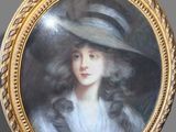 portrait of a lady in a hat by a gold frame
