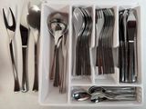 a white tray with silverware and spoons in it