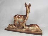 une figurine représentant un cerf et un faon, posée sur un socle en bois