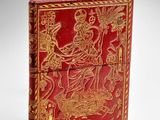 an antique red and gold book with a picture of a woman on a horse