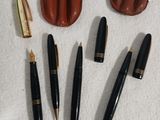 quatre stylos et un étui à stylos posés sur une table