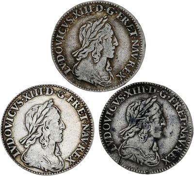 trois pièces d'argent sur lesquelles figurent respectivement la tête d'une femme et celle d'un homme