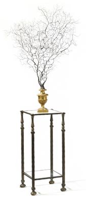 un vase contenant une branche, posé sur une table