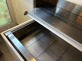 an open oven with a drawer in the middle of it