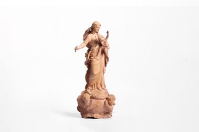 une image représentant une statue d'une femme tenant un oiseau sur un rocher