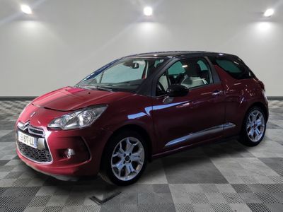 Une Citroën rouge est garée sur un sol carrelé à damier
