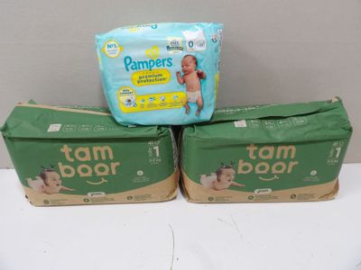 three boxes of baby diapers sitting on top of a table