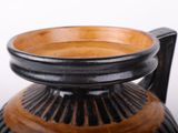 a black and brown vase sitting on a table