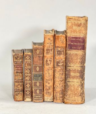 plusieurs vieux livres sont alignés sur une surface blanche