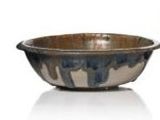 un bol marron et bleu posé à côté d'un vase marron et blanc