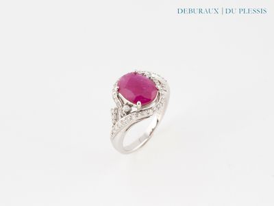 un gros plan d'une bague sertie d'une pierre rose et de diamants