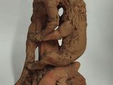 statue of a woman sitting on a rock with a dog