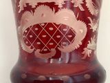 a red vase with a picture of a castle on it