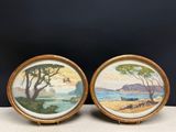 pair of framed paintings of a beach scene with trees and water