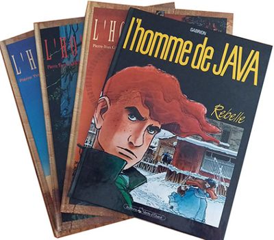trois livres sont empilés sur une surface blanche