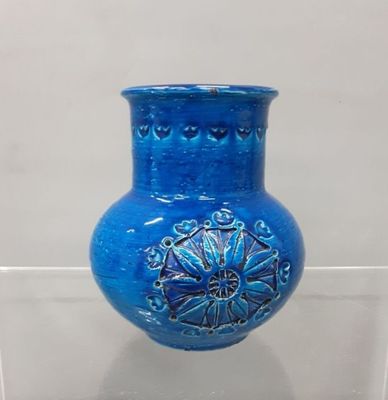 a blue vase that is on display on a clear shelf