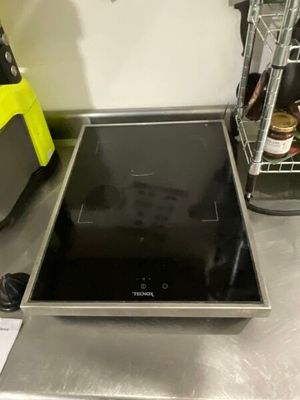 a black stove top sitting on a counter in a kitchen