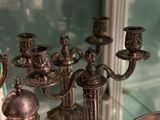 a lot of silver candles that are sitting on a glass table