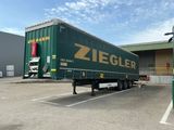 un camion garé sur un parking, avec un bâtiment en arrière-plan