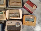 many old fashioned radio ' s sitting on the ground