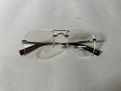 une paire de lunettes posée sur une surface blanche, avec un fond blanc