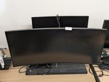 a desk with two monitors and a keyboard on it