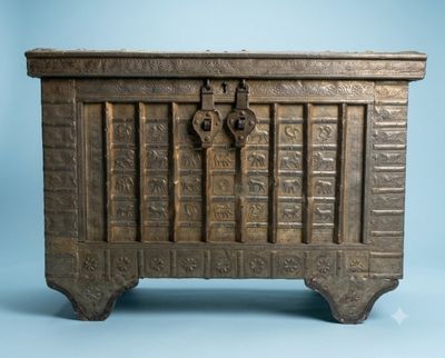 un vieux coffre en bois orné de sculptures élaborées sur fond bleu