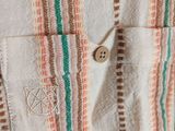 a close up of a shirt with a button in the pocket