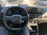someone is sitting in the driver ' s seat of a car with their feet on the steering wheel