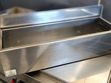 une boîte en métal avec un couvercle, posée sur une cuisinière