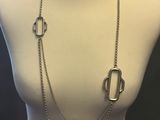 a white mannequin torso with a silver necklace on it
