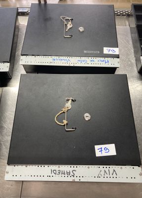 trois boîtes noires posées sur une table en métal