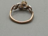 a gold ring with a flower on it on a table