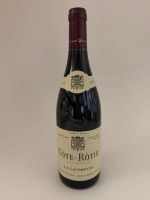 a bottle of wine sitting on top of a white table