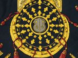 a picture of a gold and black clock with red tassels on it