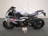 motorcycle parked on a black and white checkered floor in front of a white wall