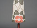 an image of a table lamp with a red flower shade on it