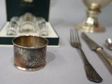 a silver cup sitting on a table next to a box of silverware
