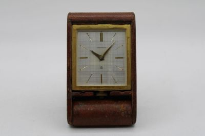 an image of a small wooden clock on a white surface